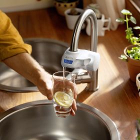 Eine Frau füllt am ON TAP V-MF ein Glas BRITA gefiltertes Wasser