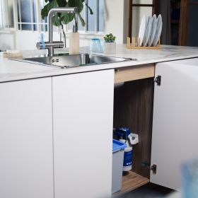 Ein eingebauter P1000 Filter in einer weißen Küche unter der Spüle von der BRITA 3 Wege Küchenarmatur 