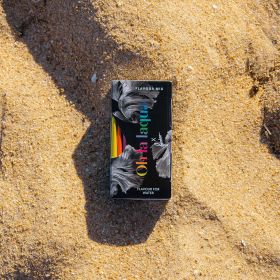 Eine OHLALAQUA Flavour-Mix Packung liegt auf Sand