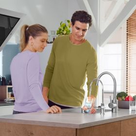 Mann schenkt sich mit BRITA mypure P1 Wasser ein Ein Mann steht neben einer Frau in der Küche und schenkt sich mit BRITA mypure P1 Wasser ein