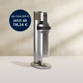 Der BRITA Wassersprudler sodaTRIO pro in Edelstahl vor einem beigefarbenen Hintergrund 
