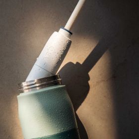 Nahaufnahme eines BRITA LARQ iQ Filter Straw mit  Wassertropfen beim Einsetzen in die Flasche.