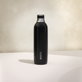 Eine große schwarze BRITA sodaTRIO Edelstahlflasche mit beigem Hintergrund