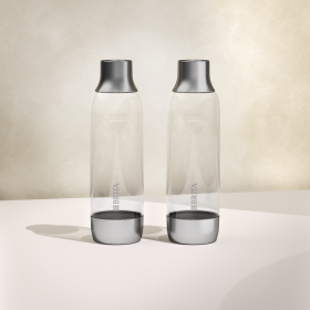Zwei BRITA sodaTRIO PET Flaschen nebeneinander mit beigem Hintergrund