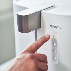 Mit dem Finger wird ein Knopf des yource pro top Wasserspenders gedrückt.