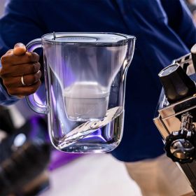 Nahaufnahme der Kanne in Stone Blue neben Kaffeemaschine.