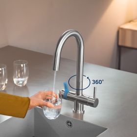 Wasser fließt aus der 3 Wege Küchenarmatur in ein Glas In der brauner Küche fließt Wasser aus der BRITA 3 Wege Küchenarmatur in ein Glas