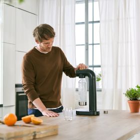 Mann sprudelt Wasser mit BRITA sodaONE in Küche. Ein Mann sprudelt Wasser mit dem BRITA sodaONE Wassersprudler.