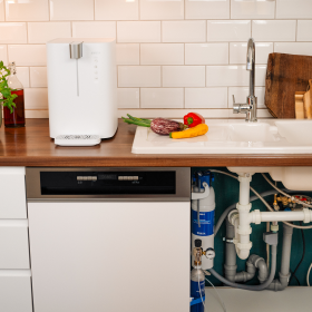 BRITA yource pro top auf der Küchenarbeitsfläche und unter dem Spülbecken sind die Filterkomponenten sichtbar