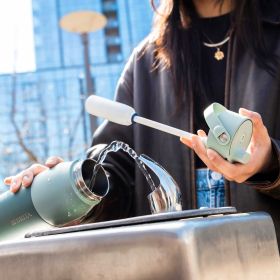 Person befüllt eine grüne BRITA LARQ Bottle an einem öffentlichen Trinkbrunnen.