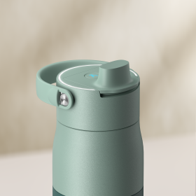 Detailaufname des Deckels der BRITA LARQ iQ in Grün vor einem beigen Hintergrund.