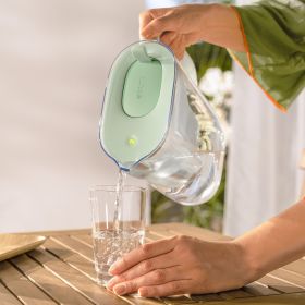Frau füllt ihr Wasserglas mit dem BRITA Tischwasserfilter Style eco auf.