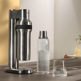 BRITA sodaTRIO pro in Küche mit Flasche und Glas BRITA sodaTRIO pro Wassersprudler steht neben einer Glasflasche und einem Glas Wasser.