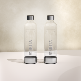 Zwei BRITA sodaONE Flaschen beiger Hintergrund Zwei BRITA Wassersprudler sodaONE Flaschen mit Edelstahlelementen im beigen Hintergrund