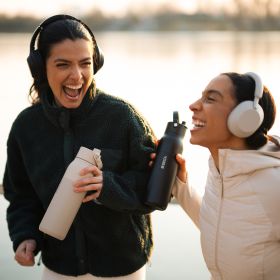 Zwei junge Frau trinken während sie joggen Wasser mit der BRITA LARQ Filterflasche