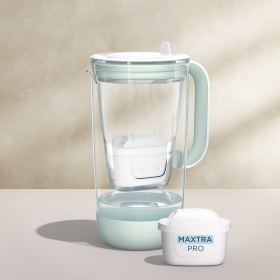 Ein Tischwasserfilter aus Glas in der Farbe Grün mit einem beigefarbenen Hintergrund