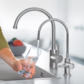 Mann füllt mit BRITA mypure P1 Wasserglas auf Ein Mann füllt in einer Küche ein Wasserglas mit dem BRITA mypure P1 auf