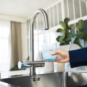 Es wird ein Glas Wasser durch den BRITA 3-Wege-Hahn gefüllt
