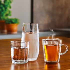 Drei Gläser mit verschiedenen Getränken: zimmerwarmes Wasser, kaltes Wasser und Tee